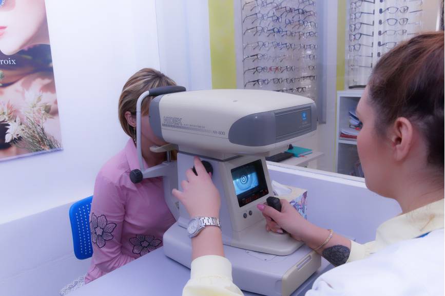 Okulistka badająca białą maszyną wzrok kobiecie 