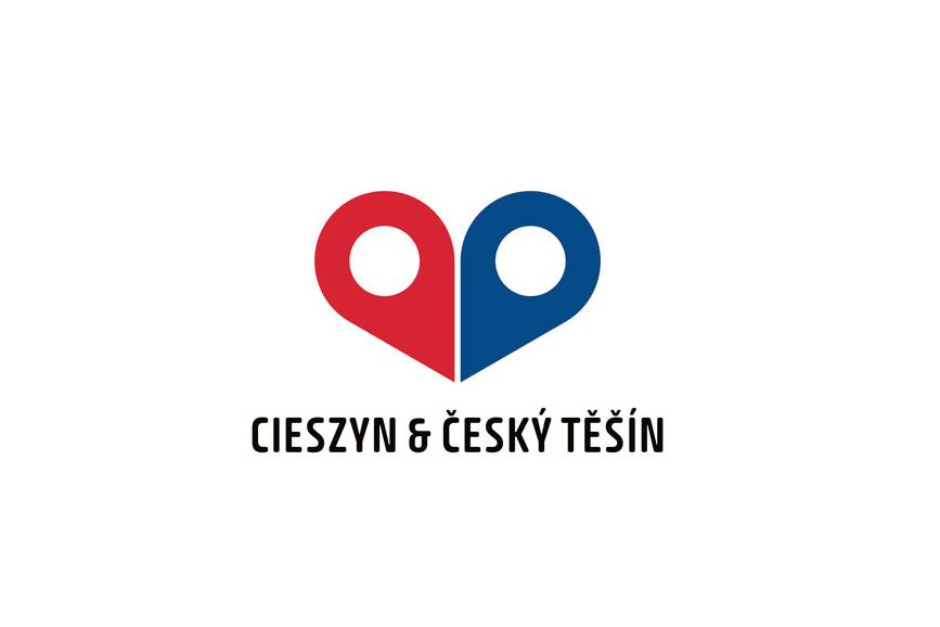 Zdjęcie przedstawia nowe logo Cieszyna i czeskiego Cieszyna, ma kształt przypominający serce  przedzielone na pół z 2 białymi kołami, lewa strona tego serca jest czerwona, a prawa niebieska 