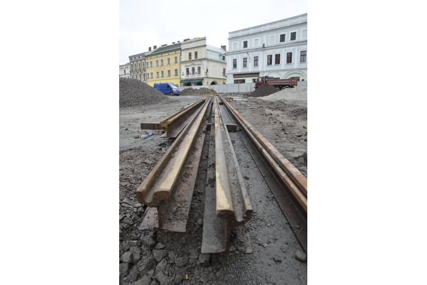 Zdjęcie przedstawia szyny tramwajowe wykopane, leżące na ziemi na rynku w Cieszynie, na dalszym planie fragmenty kamienic, fot. UM Cieszyn/FB