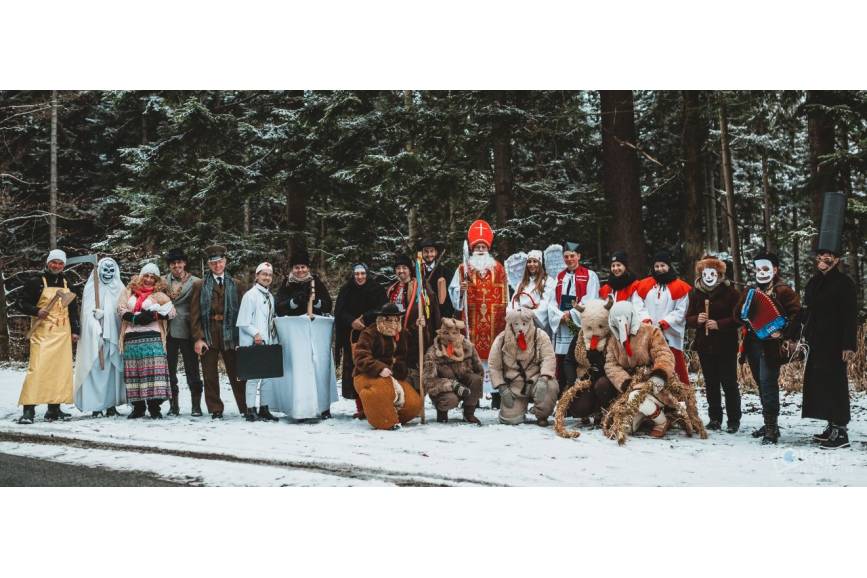 Zdjęcie przedstawia grupę około 30 osób przebranych w obrzędowe stroje przedstawiające np. biskupa, cygankę, niedzwiedzia