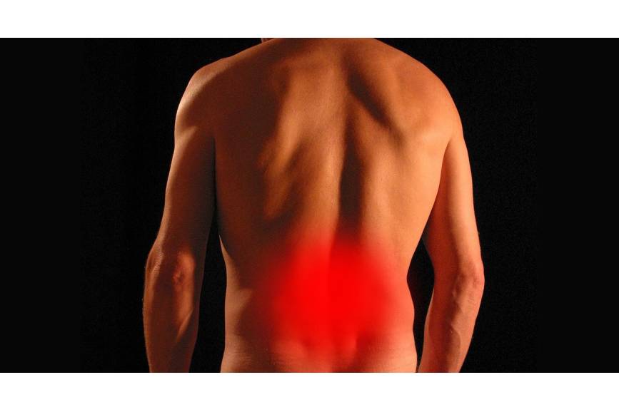 Zdjęcie pleców mężczyzny, z czerwonym punktem symbolizującym ból w okolicach nerek