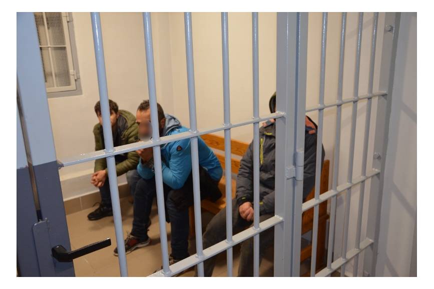 Mężczyźni siedzący w celi